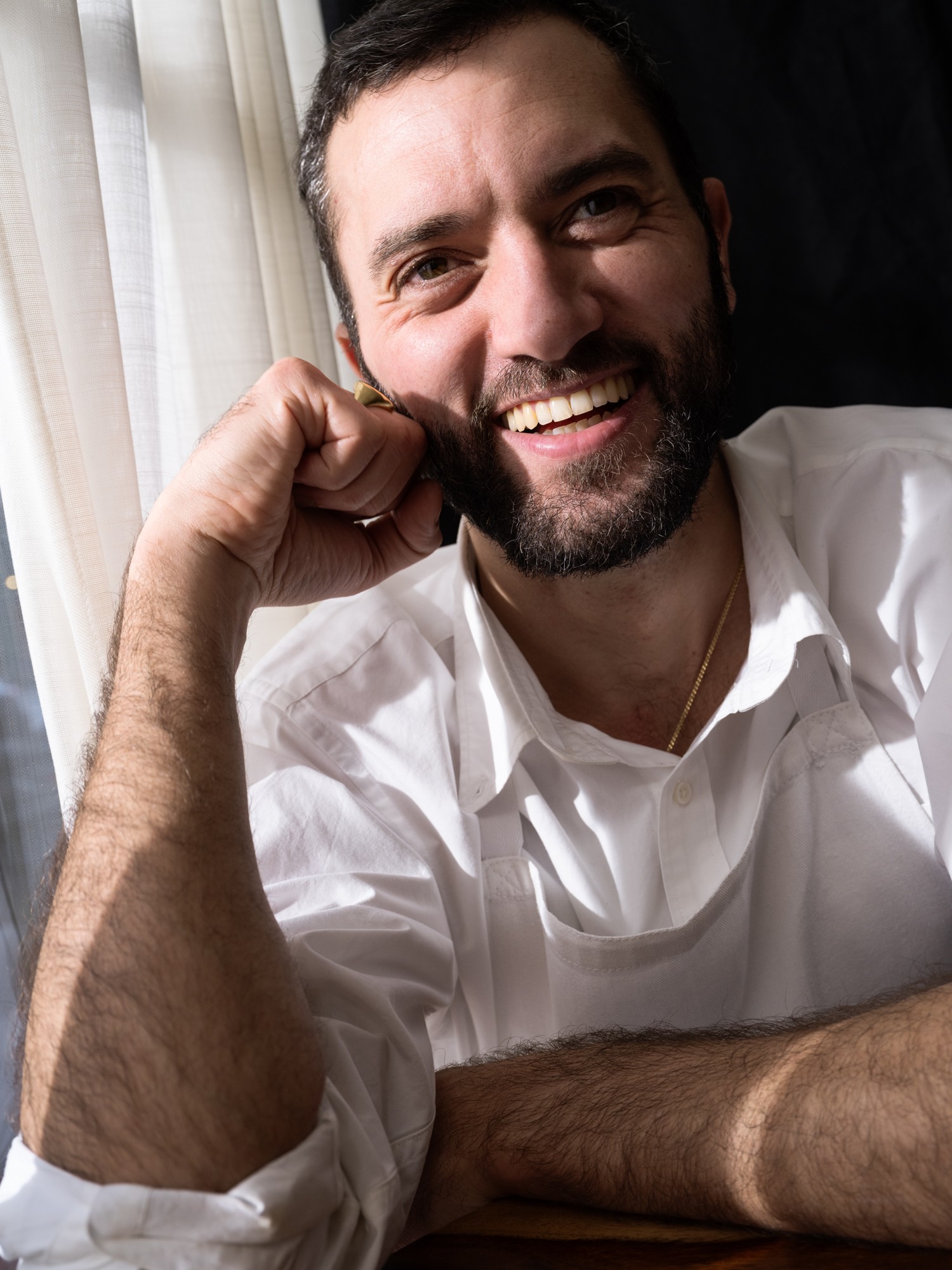 Jérémy, souriant, assis près de la fenêtre